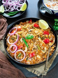Shahi Veg Biryani recipe in a black plate with mint leaves