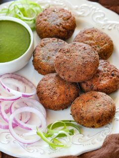 Veg Galouti kebab on a plate with onion rings